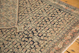 Intricate corner of an antique Senneh rug, inverted Herati motif in navy, blush, ivory, with wear.