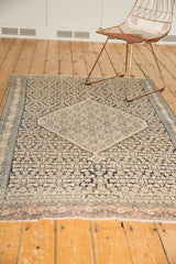 Intricate lower border of an antique Senneh rug, displaying blush floral motifs and Herati pattern.