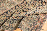 Detailed Herati motif in dusty blush and dark navy on an antique Senneh rug.