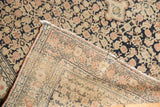 Early 20th century Antique Senneh rug's hand-knotted foundation, fringed edge, and worn navy pile.