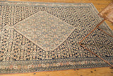 Reciprocating Herati motif in navy and blush tones on an antique Senneh rug with mostly even wear.