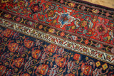 Vintage Malayer rug's navy and cherry red floral patterns with intricate ivory border.
