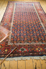 Vintage Malayer carpet showcasing allover germinating floral motifs in navy blue and cherry red.