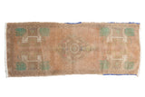 Distressed vintage Oushak rug with central medallion, plant motifs, apricot, beige, and mint green. 1'7