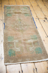Distressed Oushak rug mat runner side, with blue edge, worn pile, and visible foundation.