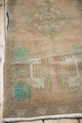 Distressed Oushak rug corner, revealing low pile with faint foundation, muted patterns.
