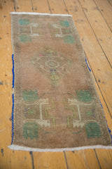 Distressed Oushak rug pile in apricot and mint green, showing aged fringe and blue cording.