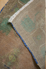 The rug's tightly woven beige foundation and blue secured side edging.