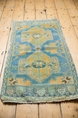 Sky blue and gold geometric patterns with distressed texture on a vintage Oushak rug.