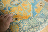 Vintage Distressed Oushak rug's soft texture in gold, sky blue, and mint green.