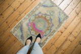 Angled corner Vintage Distressed Oushak rug, showing worn fringe and pale copper-mint border.