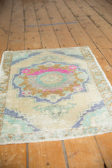 Distressed Oushak rug pile with bubblegum pink, mint, and pale copper medallion details.
