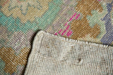 Hand-knotted foundation and distressed vintage Oushak rug pile with pink, mint, and copper hues.