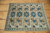 Vintage Oushak rug corner showing ivory, teal, coffee blossomed bud pattern and fringe.