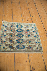 Distressed Oushak square mat corner, deep teal geometric border, stylized coffee brown floral motifs.