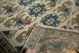 Distressed Oushak rug detail: antique ivory, deep teal floral pattern, and woven reverse.
