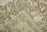 Distressed beige Oushak rug pile showing knot heads and secured side edge.