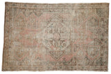 Vintage distressed Oushak rug with a worn geometric medallion, soft rose, ivory, and green hues.