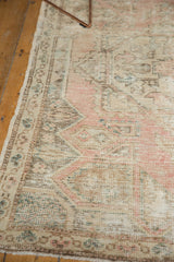 Distressed texture of vintage Oushak rug showing geometric pattern and border in pale rose and ivory.