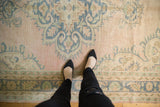 Pale pink, denim blue distressed Oushak rug with scalloped medallion contour.