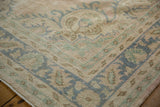 Textural close-up of distressed Oushak hand knotted pile, featuring worn blue, green, and pink motifs.