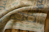 Distressed Oushak carpet pile, showing even wear, faint foundation, and secured edge.