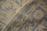 Distressed Oushak rug pile featuring even wear, pale denim blue, dusty pink, and ivory.