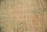 Distressed texture of a vintage Oushak rug, featuring even wear, faint foundation, soft green.