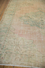 Distressed Oushak carpet with even wear, highlighting muted pale pink and seafoam green motifs.