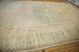 Distressed vintage Oushak rug, faded pale pink, seafoam green, even wear to foundation.