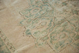Vintage Distressed Oushak rug detail, showing aged pile with seafoam green curvilinear motifs on an ivory field.