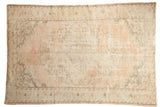 Distressed Oushak carpet with faded medallion, soft blush, ivory, and brown tones, 5'8