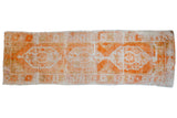 Distressed Oushak rug runner with tangerine, ivory, and beige triple medallions and geometric floral design.