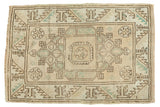 Distressed vintage Melas rug with geometric starburst and serrated leaves in beige, seafoam, coffee brown.