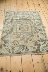 Distressed Melas rug geometric starburst-spandrel pattern in beige, brown, and seafoam green.