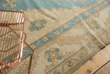 Distressed Oushak rug with heavily abrashed ivory ground and light blue geometric patterns.