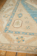 Distressed vintage Oushak rug detail: germinating tree motif, geometric bands, and worn pile.
