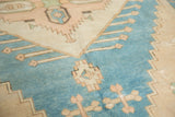 Textured distressed pile with stylized geometric motifs in turquoise, blush, and ivory.