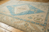 Vintage distressed Oushak rug corner with soft abrashed turquoise and ivory patterns.