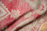 Distressed Oushak rug texture, dusty raspberry, ivory tones, showing wear to knot heads.