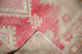 Distressed dusty raspberry pile and visible foundation, highlighting unique texture and secured fringe.