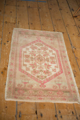 Oushak rug corner with distressed dusty rose pinwheel florals and subtle ivory, beige tones.