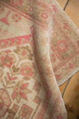Distressed vintage Turkish Oushak rug pile showing even wear, dusty rose, beige, and sand hues.