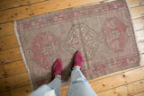Distressed Anatolian rug with worn pile, foundation visible, geometric motifs in dusty wine, ivory.