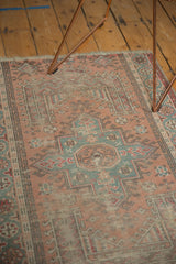Angled detail of a distressed Anatolian rug, highlighting geometric patterns and faded rose and oxidized green.