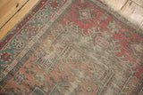 Corner detail of distressed Anatolian rug, showcasing geometric borders in cherry red and oxidized green.