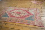 Vintage distressed Oushak rug corner, with secured edge and geometric raspberry, teal border.