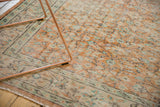 Distressed Oushak carpet with pale apricot and mint green floral vinery, foundation showing.