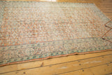Distressed vintage Oushak border, featuring pale apricot, ivory, and mint green floral motifs.