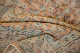 Distressed Oushak carpet's texture, showing foundation through worn apricot, ivory, and mint pile.